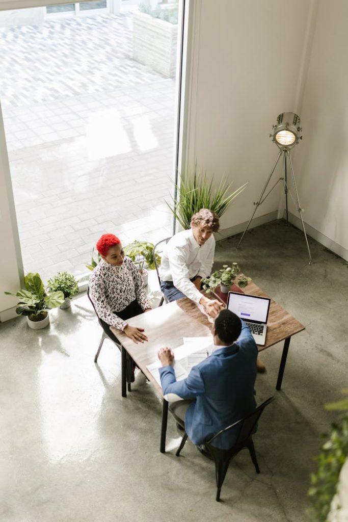 High angle view of a diverse business team concluding a meeting with a handshake, indoors.